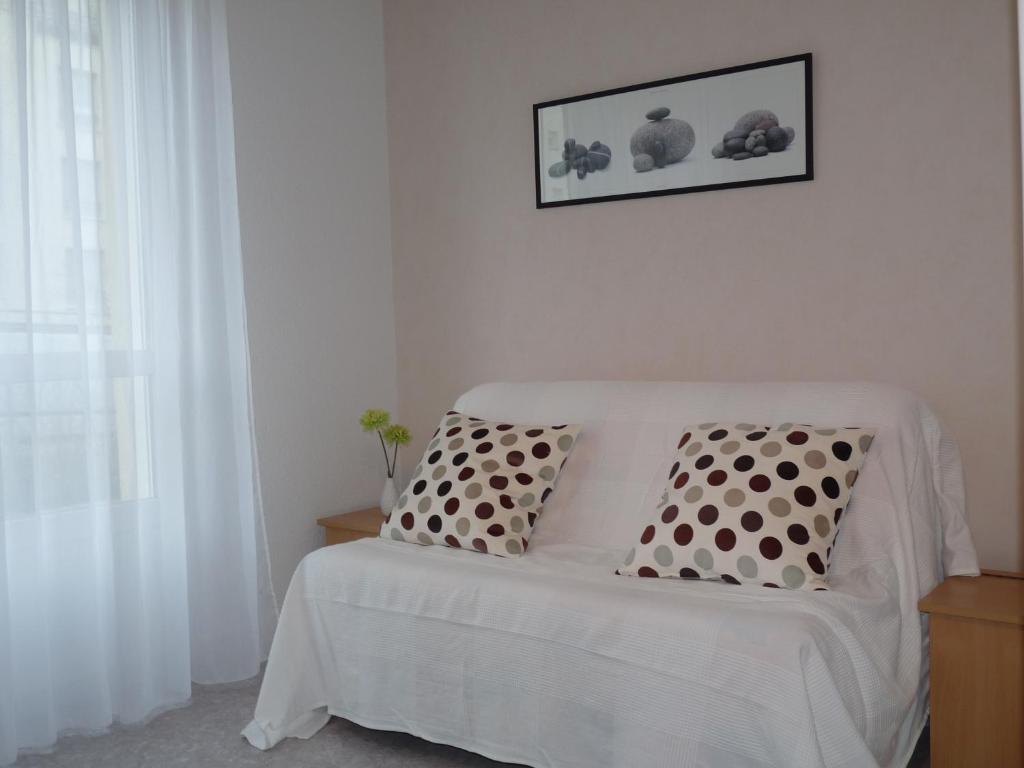 卡昂的住宿－坦博羅傑斯紀念館斯芬克斯酒店，客房内的一张带两个枕头的白色床
