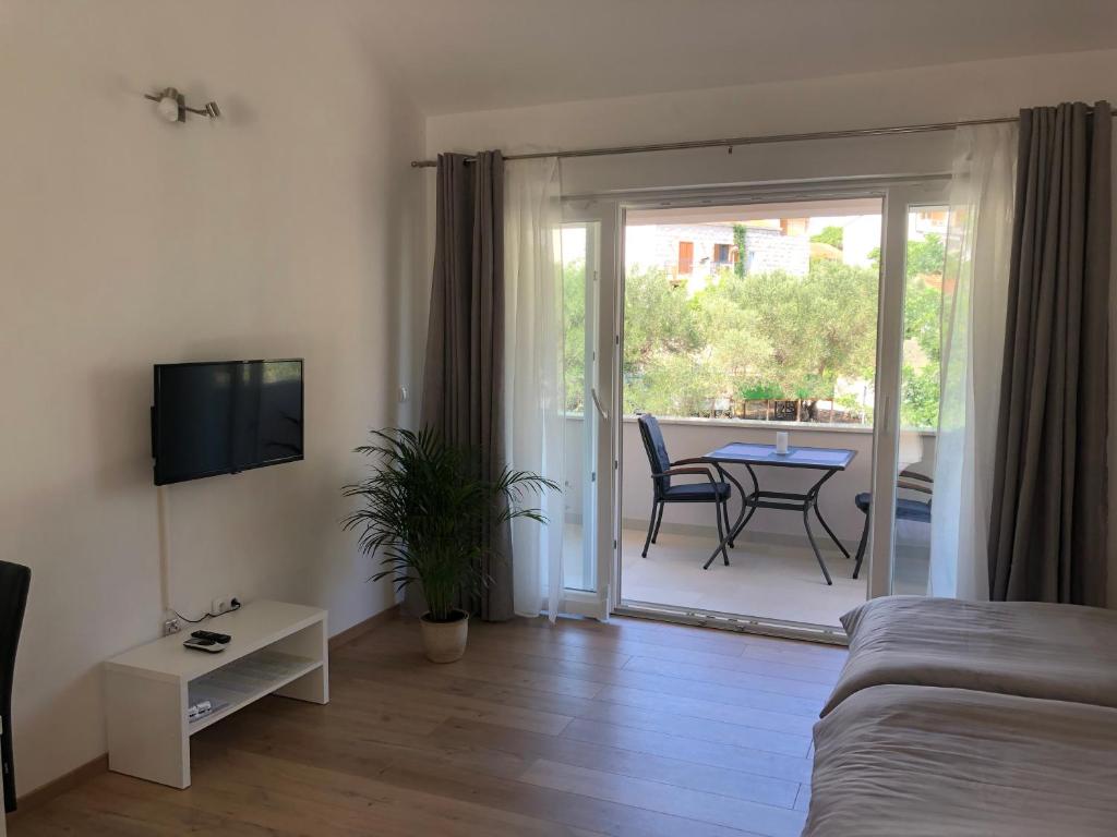 a room with a bed and a balcony with a table at Korkyra Fit suites -free gym in Korčula