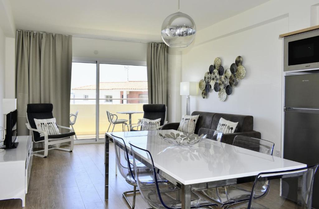 een woonkamer met een witte tafel en stoelen bij Playa Flores - Vistas al Mar in Torremolinos