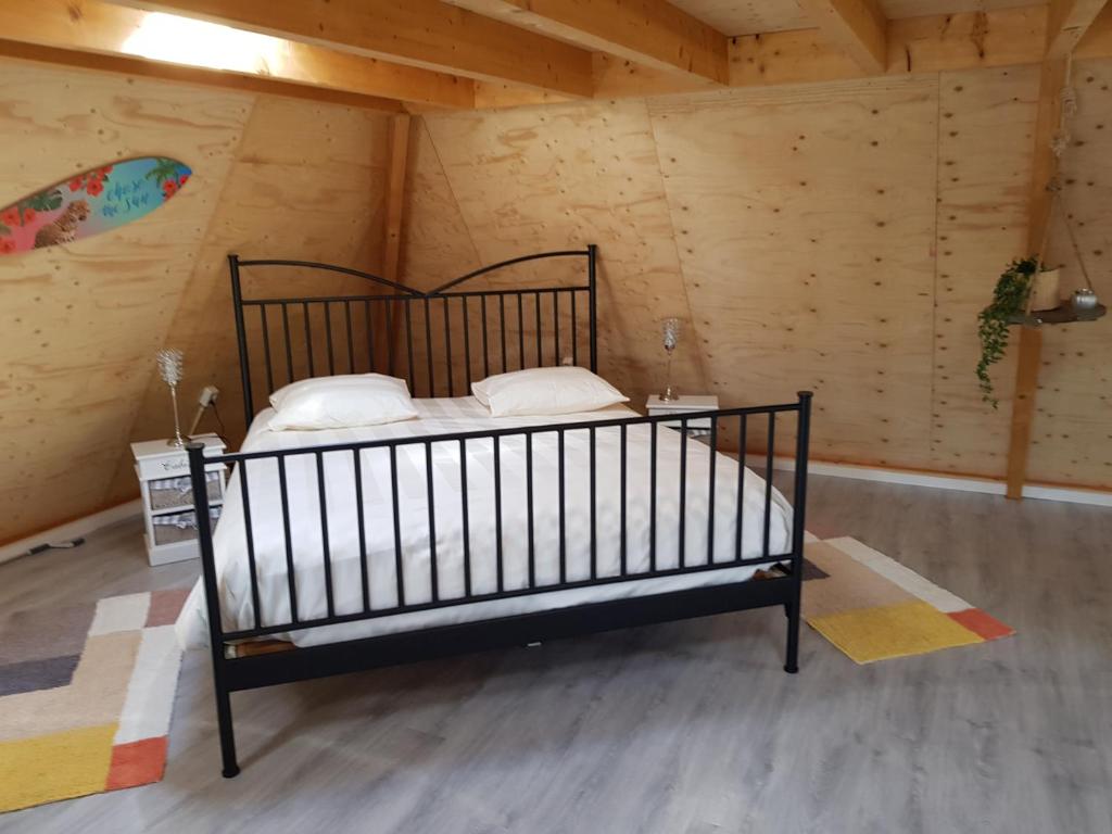 a bedroom with a bed in a room with wooden walls at De Loft in Zuid-Scharwoude