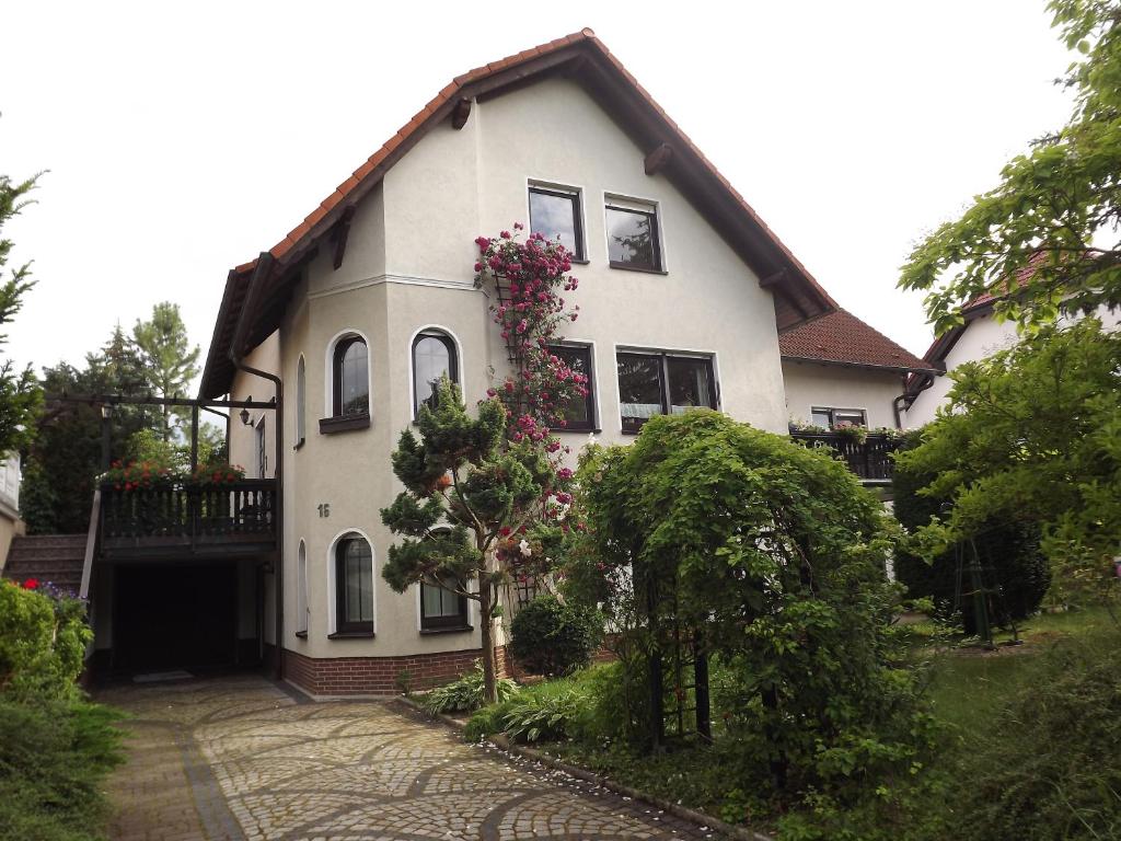 a white house with flowers on the side of it at Große Ferienwohnung am grünen Stadtrand in Erfurt