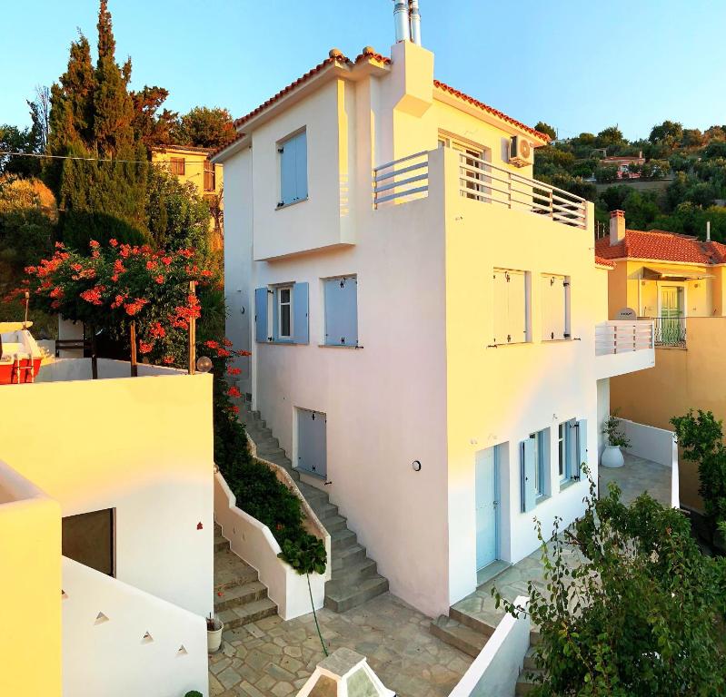 an apartment building with white walls and balconies at Kalimera homes in Skopelos Town