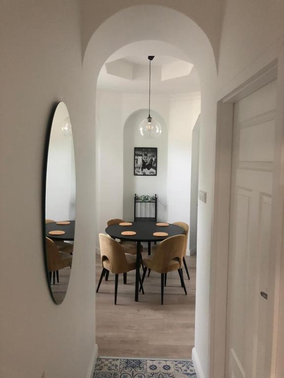 a dining room with a table and chairs and a mirror at Monte Gdynia Apartament in Gdynia