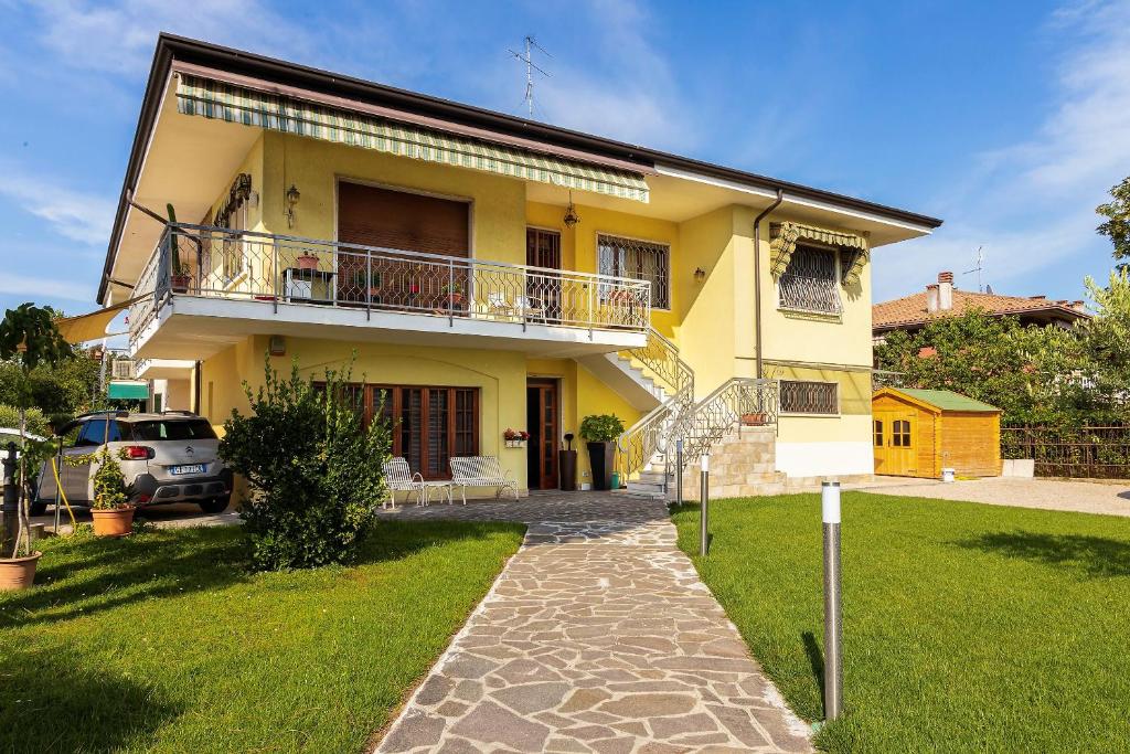 a yellow house with a balcony and a driveway at Il Melograno in Peschiera del Garda