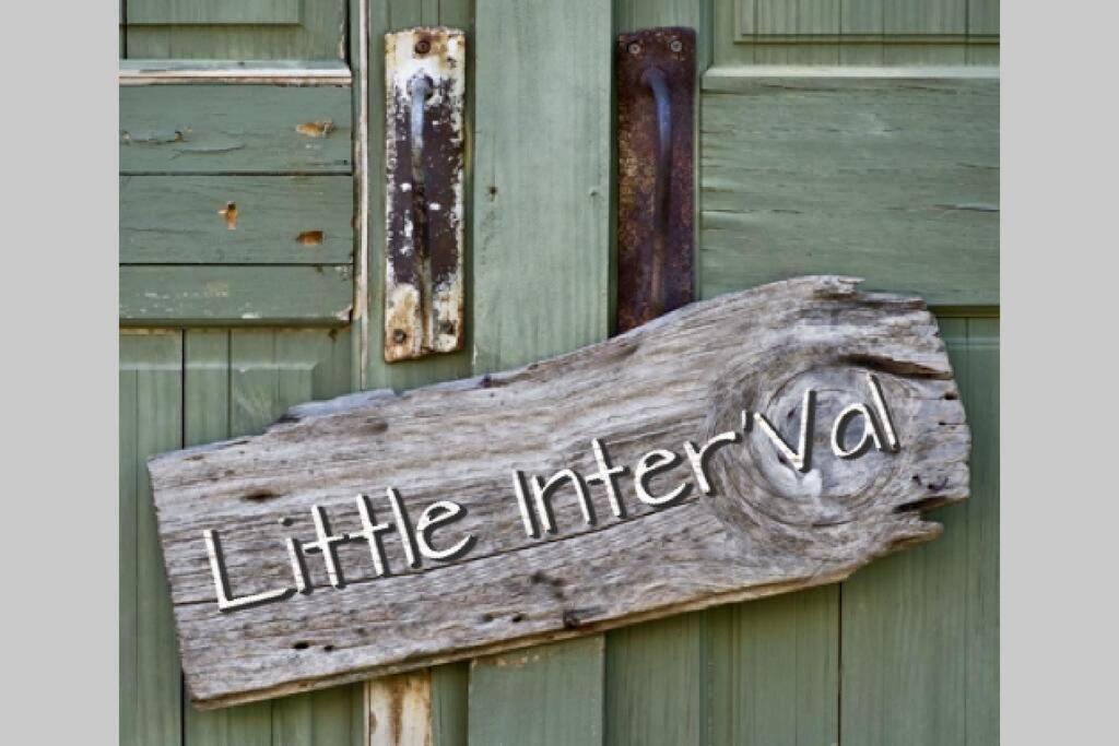 un panneau en bois sur le côté du bâtiment dans l'établissement Little InterVal, à Le Villard