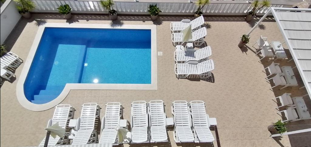 una vista aérea de una piscina con tumbonas y una piscina en Apartments Ćurić, en Trogir