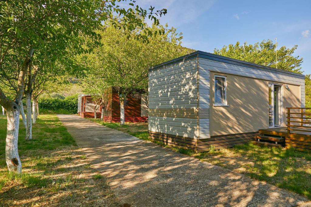 a tiny house in a field next to a path at Mobile homes village "MUNGOS" Mljet in Babino Polje