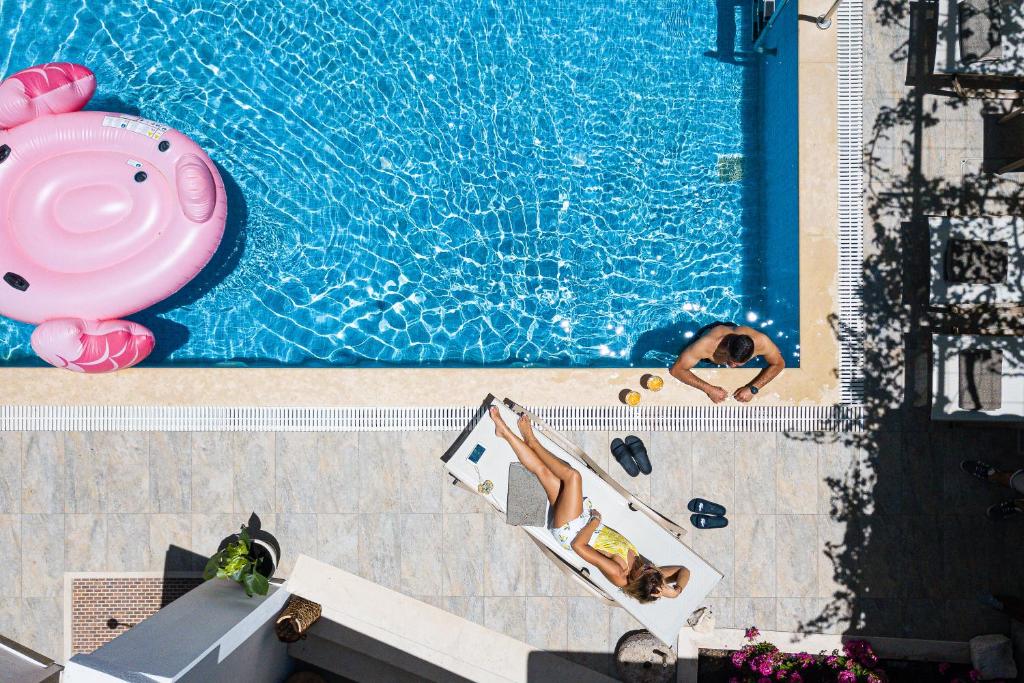 an overhead view of a pool with two people swimming at Villa Aprinia in Karé