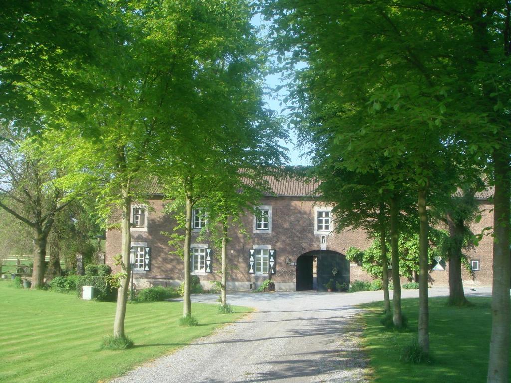 einen Eingang zu einem großen Backsteingebäude mit einer Auffahrt in der Unterkunft Hoeve Berghof in Heerlen