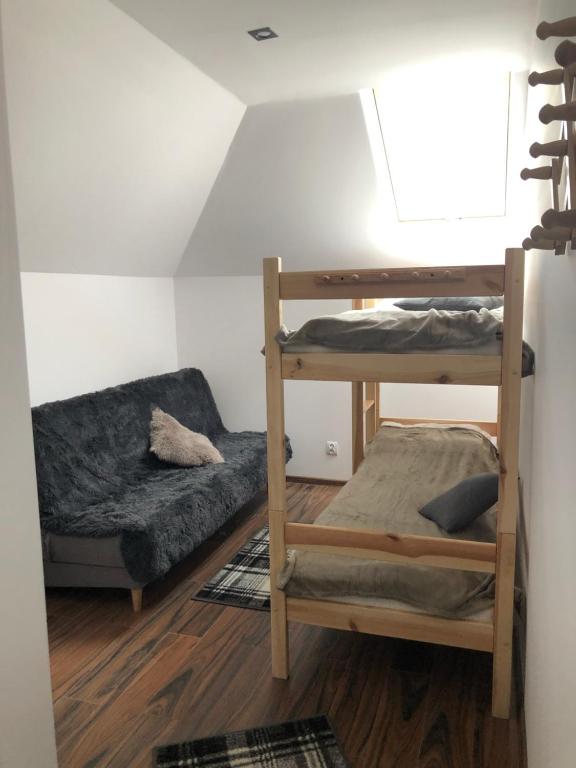 Zimmer mit 2 Etagenbetten und einem Sofa in der Unterkunft Bernat in Puławy