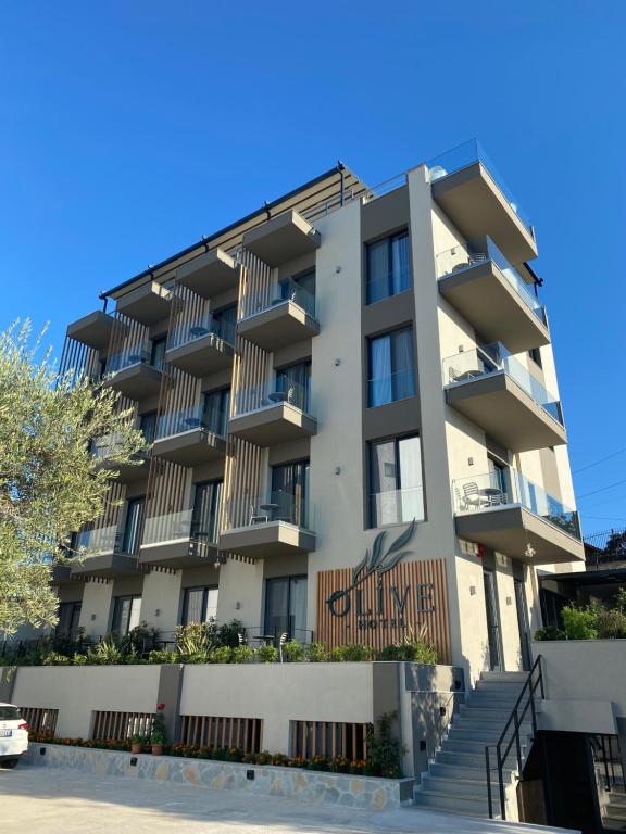 an apartment building with stairs in front of it at Hotel Olive Ksamil in Ksamil