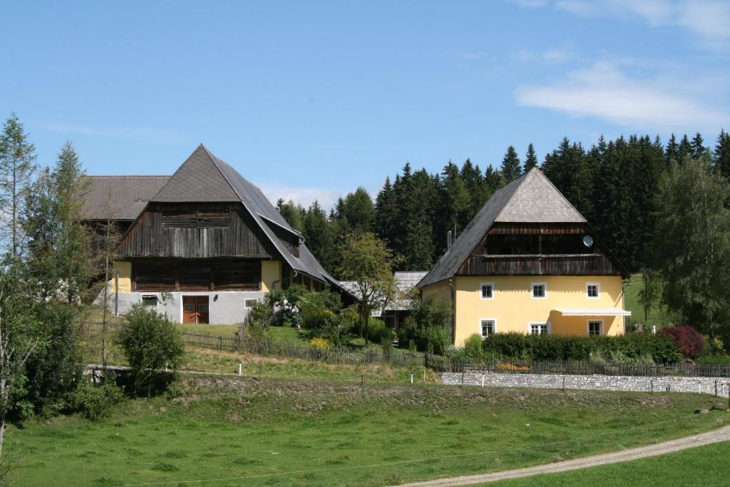 una casa con dos techos y un campo verde en Urlaub am Bio-Bauernhof Liebchen en Zeutschach