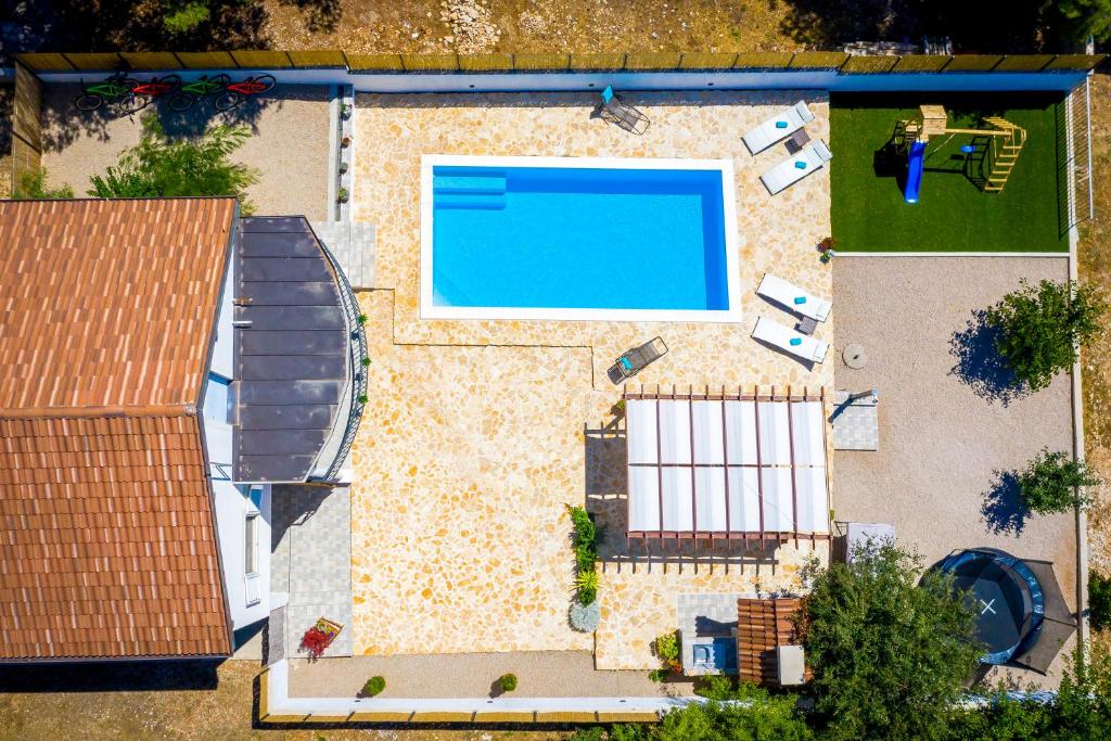 een uitzicht over het zwembad van een huis bij Villa R&B heated pool in Vrpolje