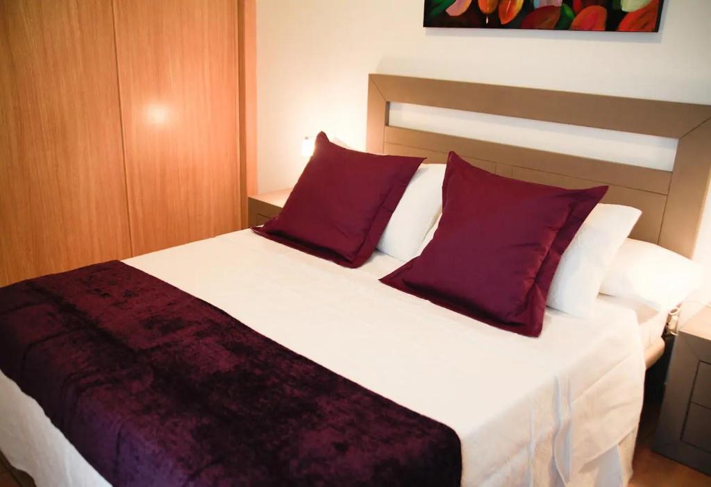 コティージョにあるJovia Vacacional El Cotilloのベッドルーム(紫色の枕が付いた大きな白いベッド付)
