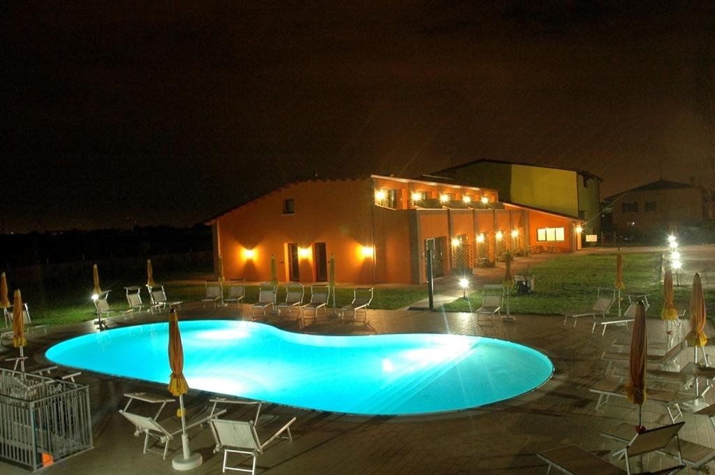 una gran piscina azul frente a un edificio por la noche en Agriturismo Aver, en Villafranca di Verona