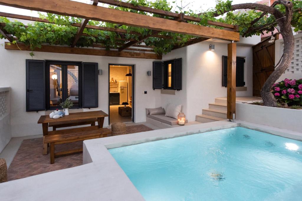 een zwembad in de achtertuin van een huis met een pergola bij Cretan Soul in Plataniás