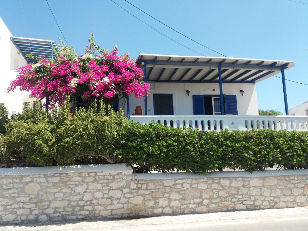 una casa con flores rosas en una pared de piedra en Cycladic House in Paros en Márpissa