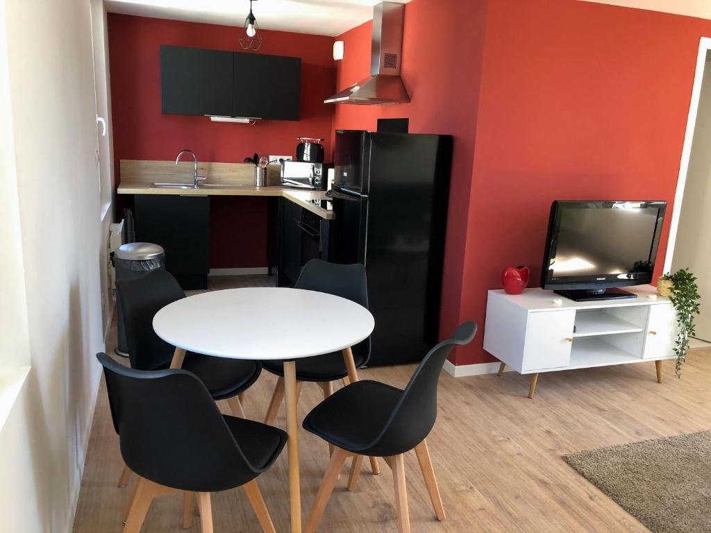 uma pequena cozinha com mesa e cadeiras num quarto em Appartement calme & lumineux proche centre em Saumur