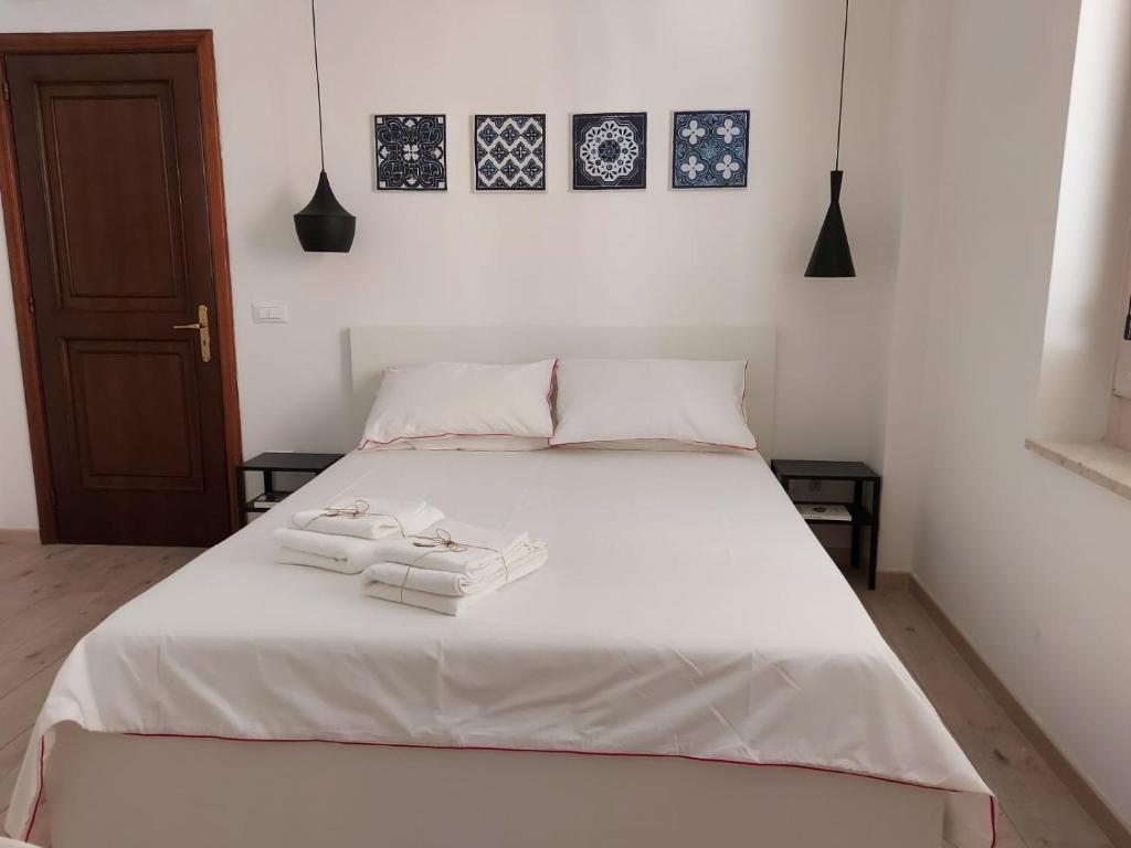 ein Schlafzimmer mit einem weißen Bett mit zwei Handtüchern darauf in der Unterkunft Isabella d'Aragona Guest House in Barletta