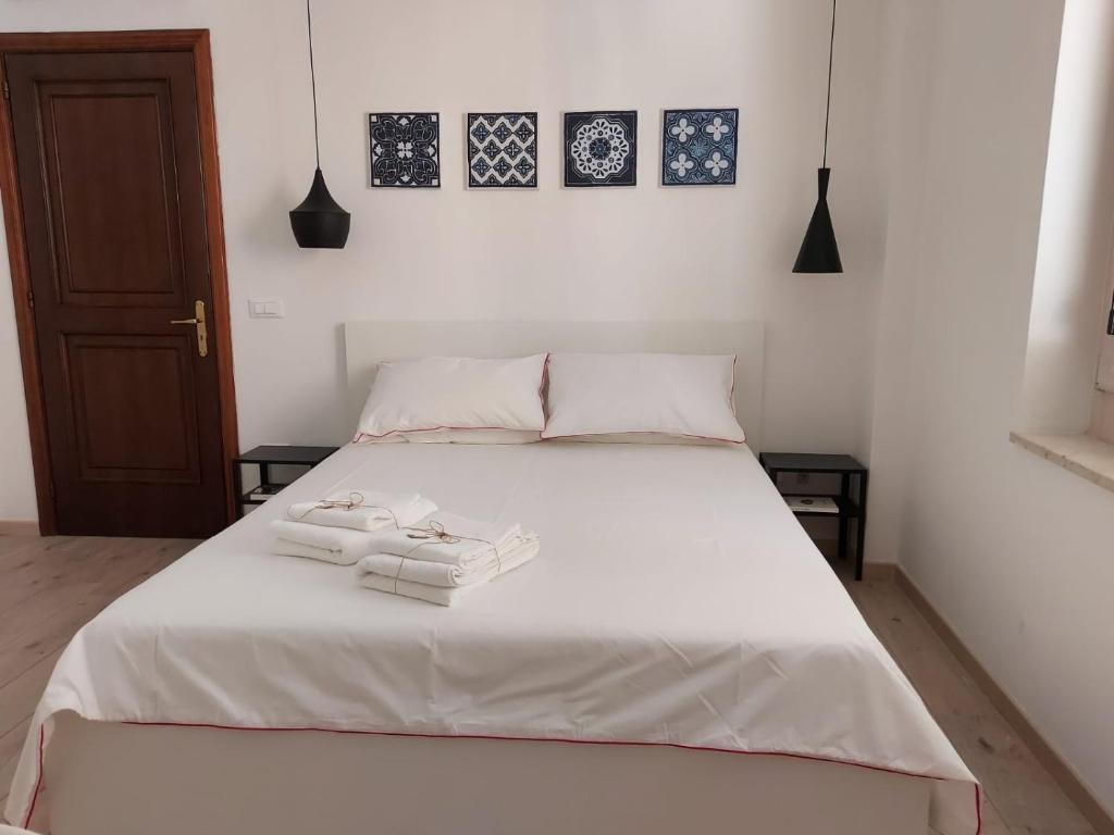 una camera da letto con un letto bianco con due asciugamani di Isabella d'Aragona Guest House a Barletta