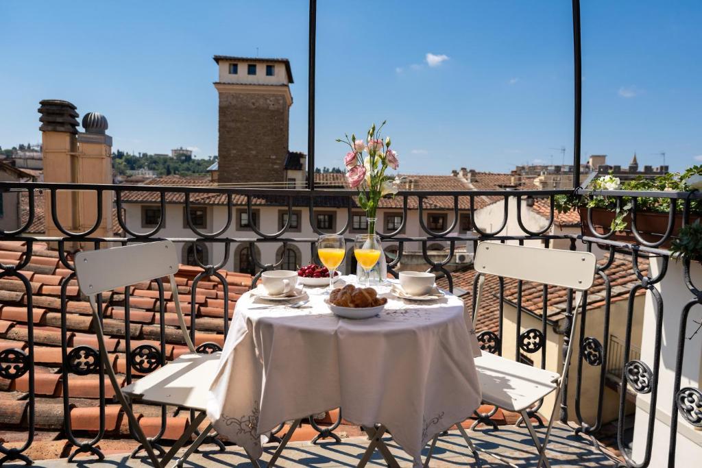 a table with food and drinks on a balcony at Terrace apt in Piazza Strozzi-center of Florence in Florence