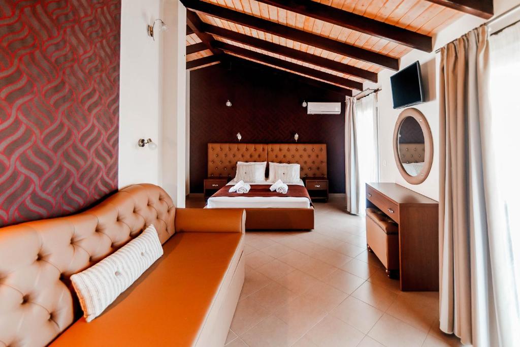 a bedroom with a couch and a bed in it at Hotel Torini in Parga