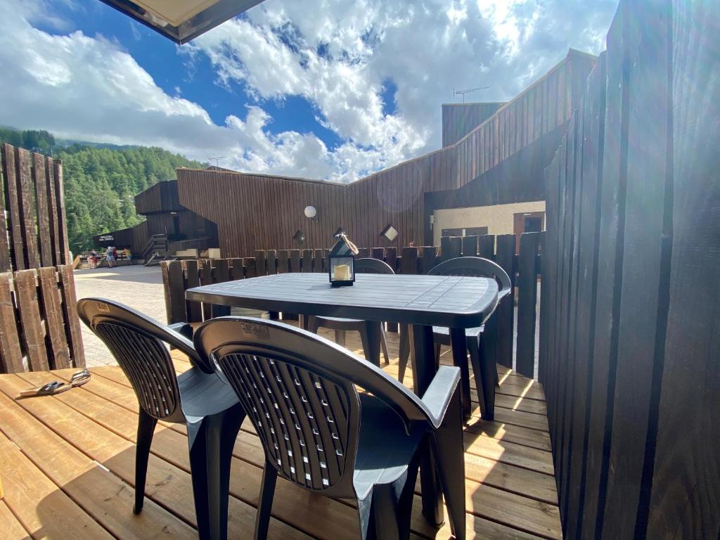 einen Tisch und Stühle auf einer Holzterrasse in der Unterkunft Orrianes'home in Les Orres