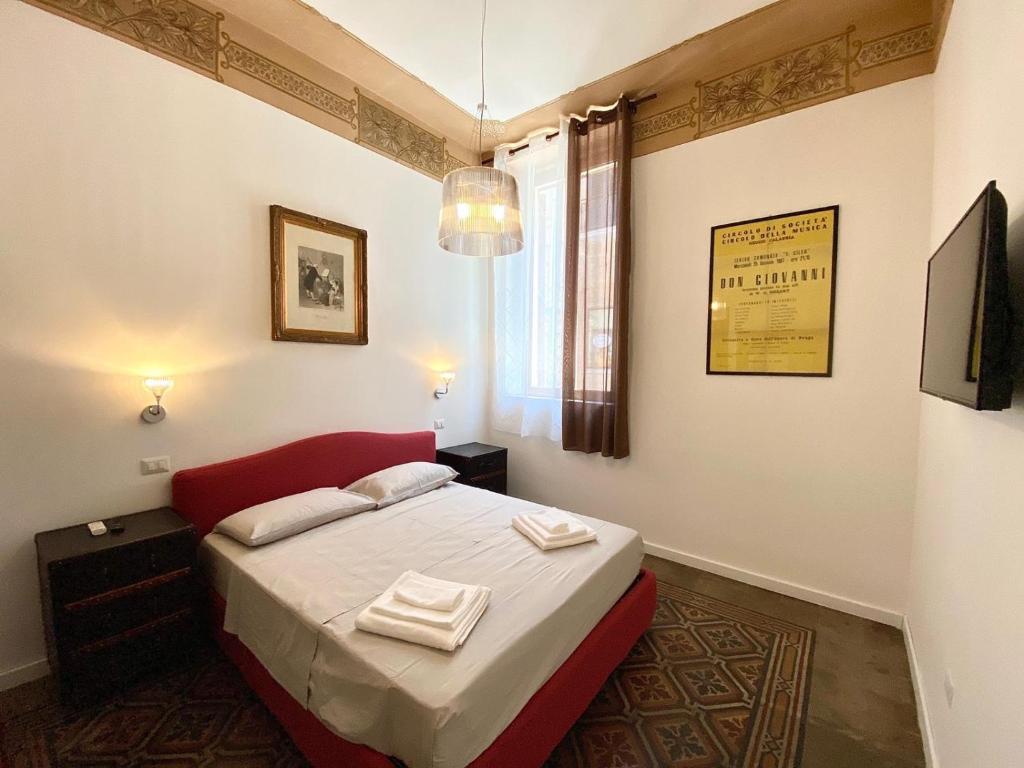 a bedroom with a bed with two towels on it at Al Teatro in Reggio Calabria