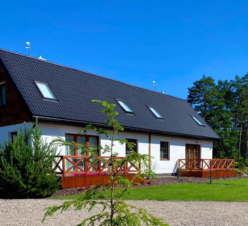 a white house with a black roof at Nad Wiartlem in Wiartel