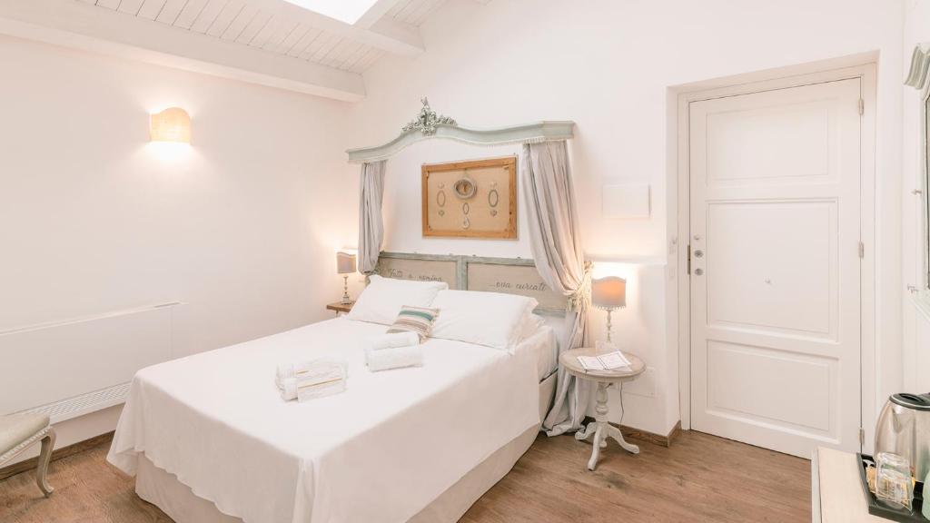 a white bedroom with a white bed and a door at Addimora Boutique Suites in Palermo