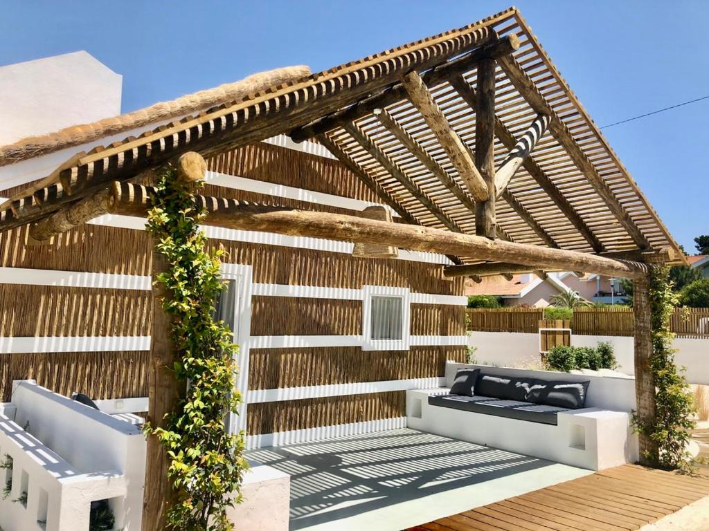 uma pérgola de madeira com dois sofás num deque em Cabana 2 da Comporta em Comporta