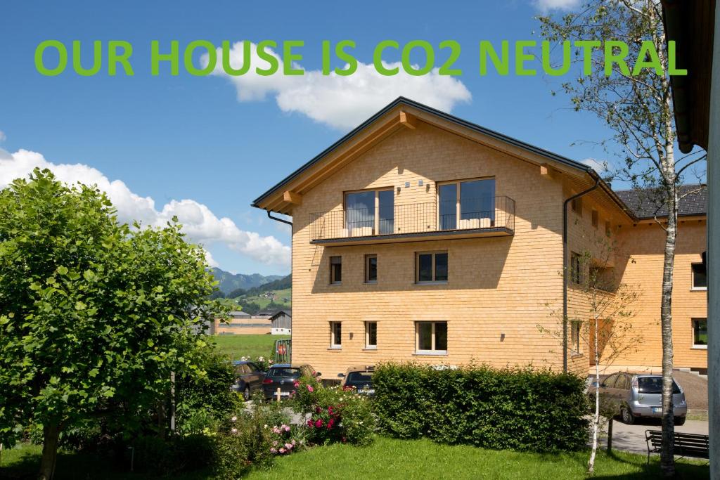 uma casa com uma placa que diz que a nossa casa é neutra em Schtûbat (Contactless Check-In) em Andelsbuch