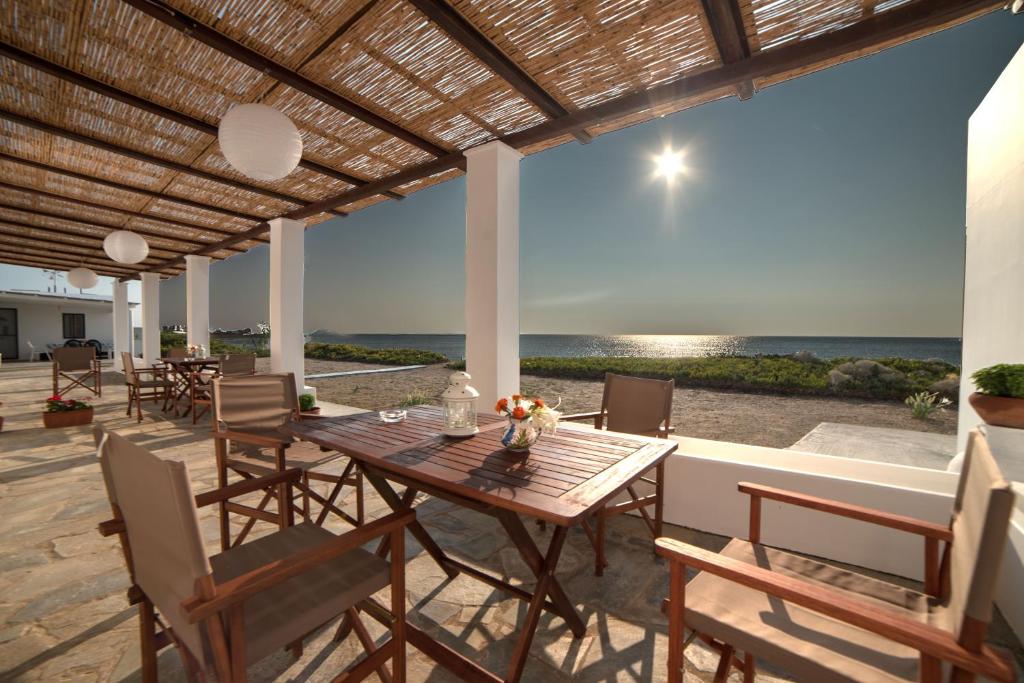 einen Holztisch und Stühle auf einer Terrasse mit Meerblick in der Unterkunft Aktaia in Skyros