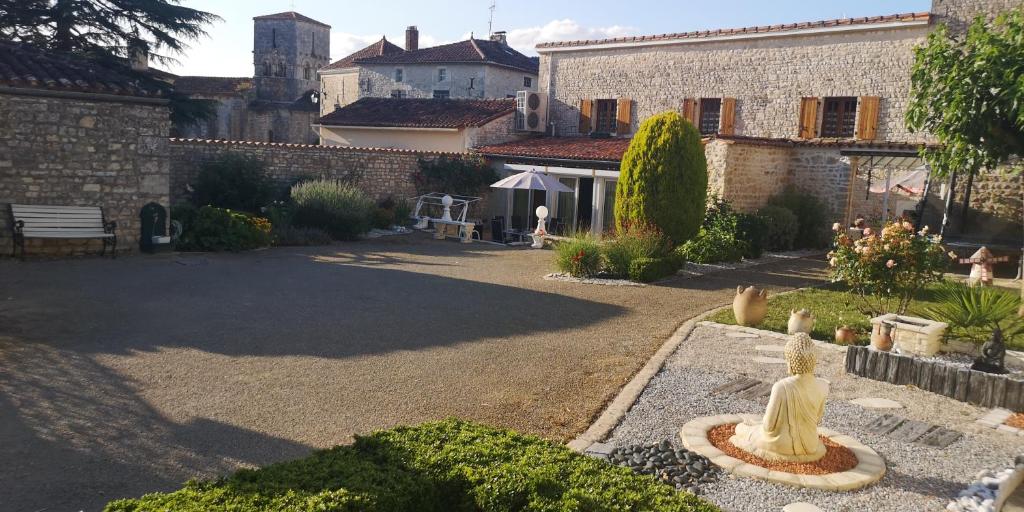 un giardino con una statua nel mezzo di un cortile di Les Quatre Saisons a Saint-Angeau