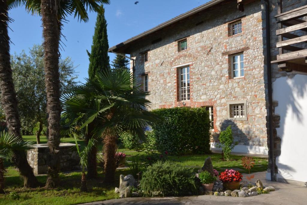 un antiguo edificio de piedra con palmeras y plantas en Apartment Monika en Udine
