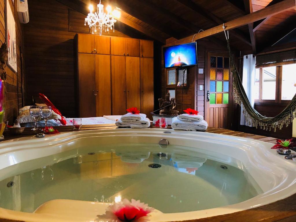 uma grande banheira num quarto com televisão em Shiva Guest House em Florianópolis