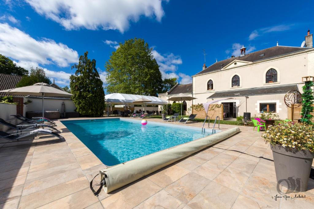 una piscina di fronte a una casa di Hôtel-Restaurant Le Prieuré devient la "Maison du Prieuré" a Vignoux-sur-Barangeon