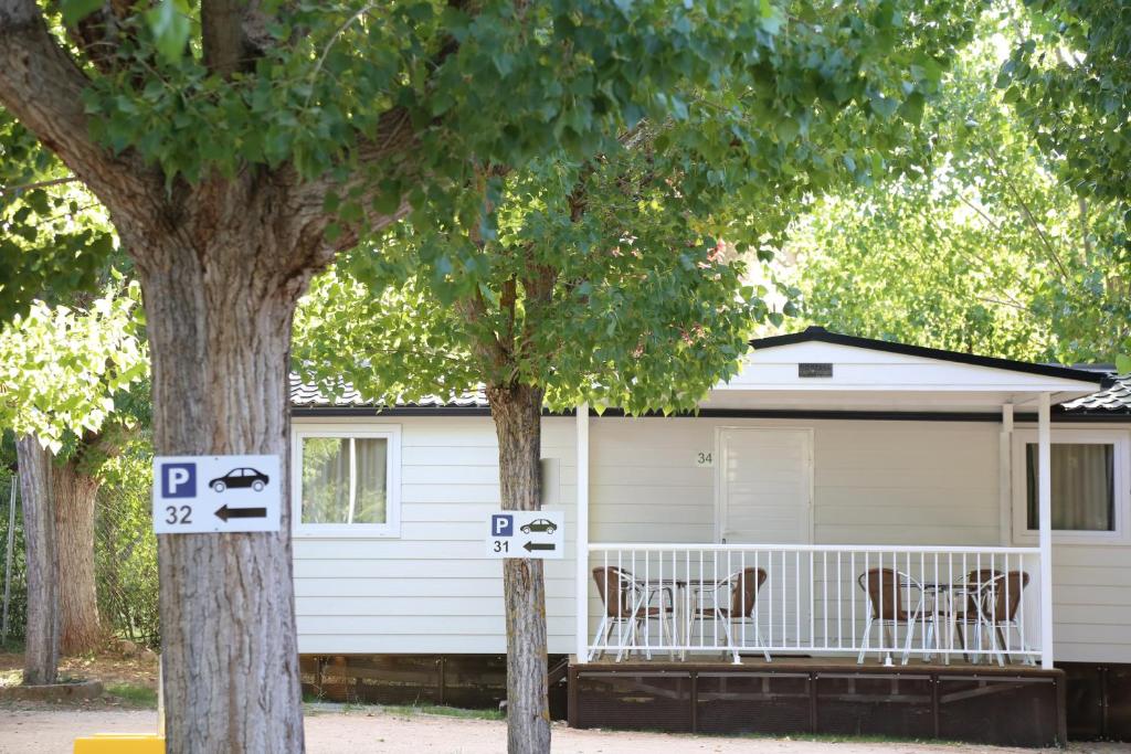 una casa blanca con dos árboles delante de ella en Bungalows y Mobil Homes Camping Regio, en Santa Marta de Tormes