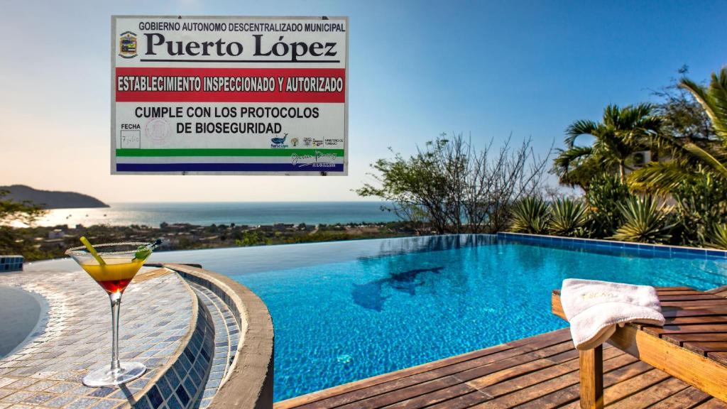 a drink sitting on a deck next to a swimming pool at Hosteria La Terraza in Puerto López