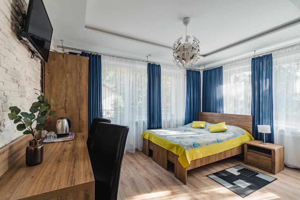 シュツァブニツァにあるWilla Śnieżynkaのベッドルーム(ベッド1台、テレビ、青いカーテン付)