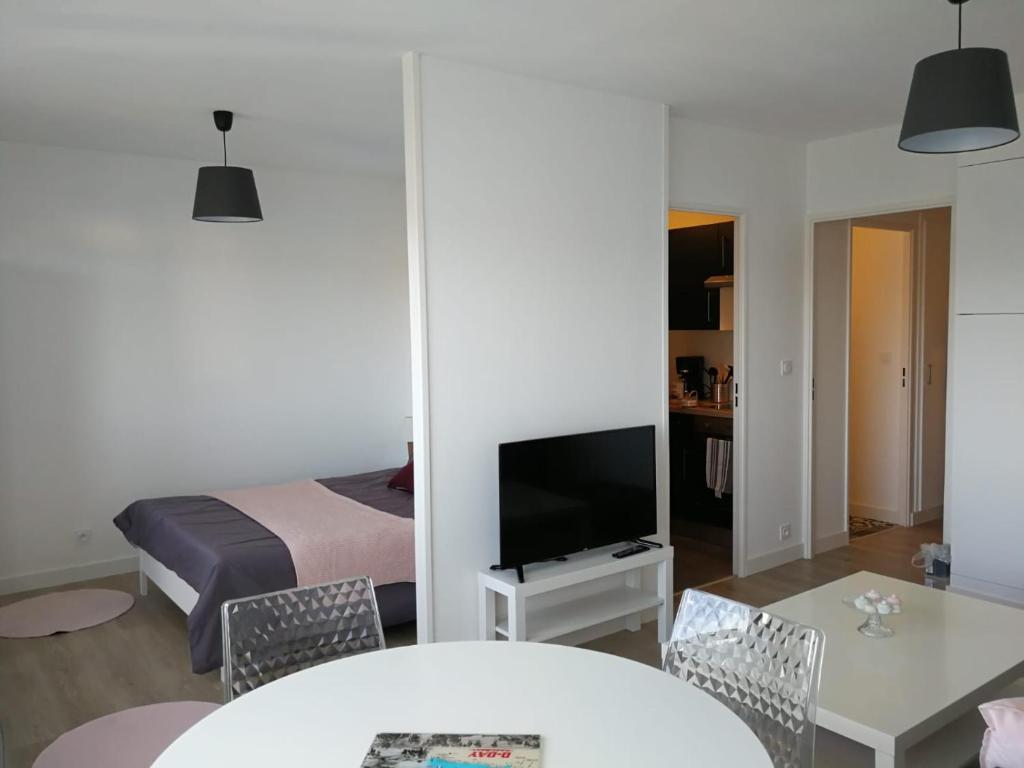 Zimmer mit einem Bett, einem TV und einem Tisch in der Unterkunft La croisette in Bernières-sur-Mer