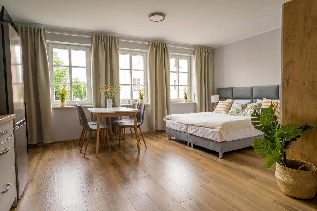 1 dormitorio con 1 cama, mesa y sillas en APARTAMENTY CENTRUM en Braniewo