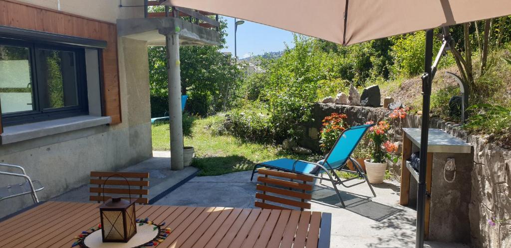 昂布朗的住宿－Le petit appart de Pomme，庭院配有桌椅和遮阳伞。