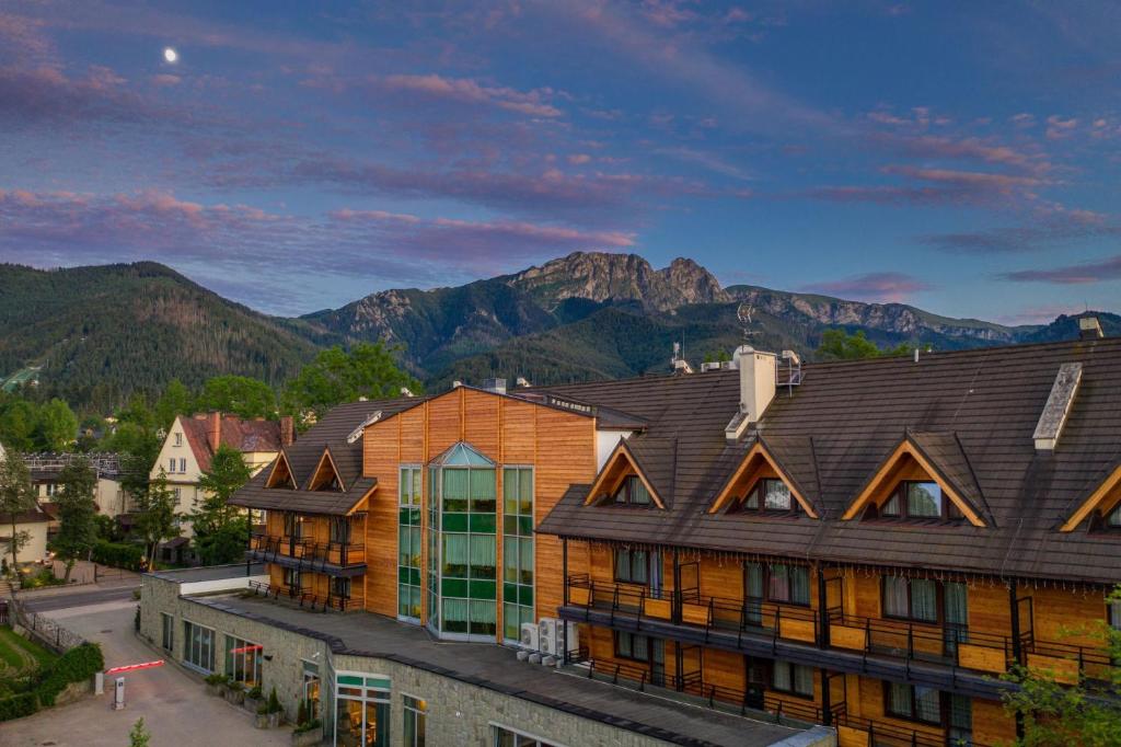 um grupo de edifícios com montanhas ao fundo em Hotel Wersal em Zakopane