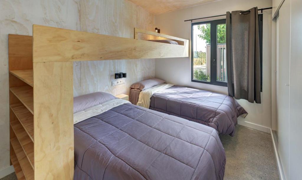 1 dormitorio con 2 camas y 1 cama elevada en Camping Globo Barcelona, en Canet de Mar