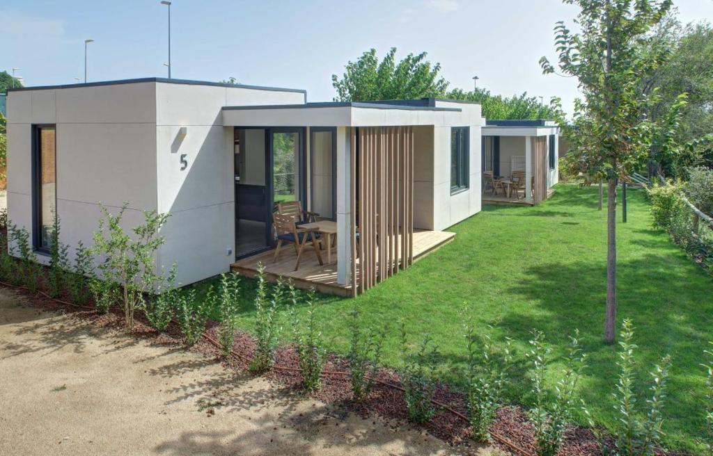 una pequeña casa blanca con patio en Camping Globo Barcelona, en Canet de Mar