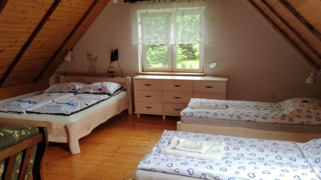 1 dormitorio con 2 camas y ventana en Brzozowy Zakątek, en Budry