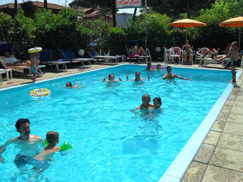 a group of people swimming in a swimming pool at Hotel Zani in Cervia