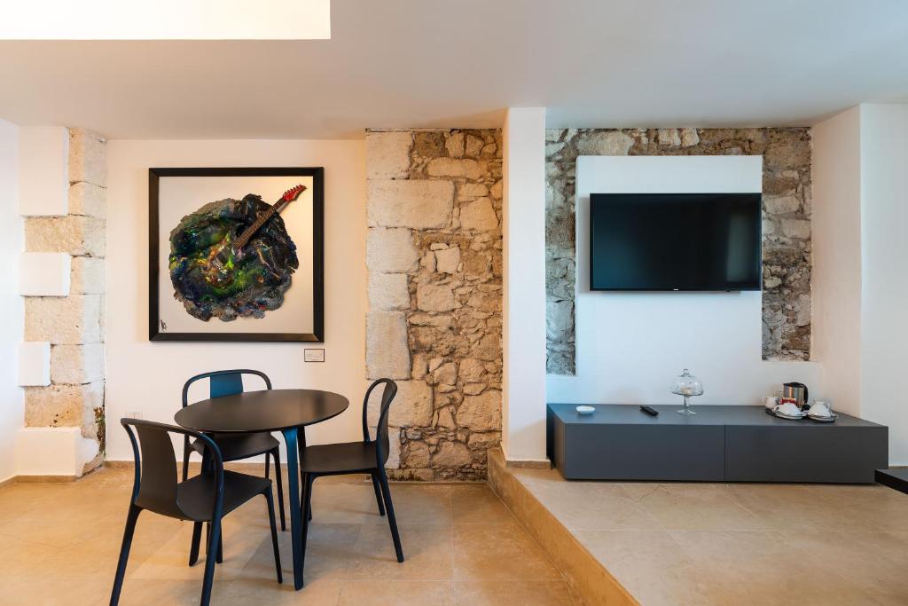 Televízia a/alebo spoločenská miestnosť v ubytovaní Re Dionisio Luxury Suites
