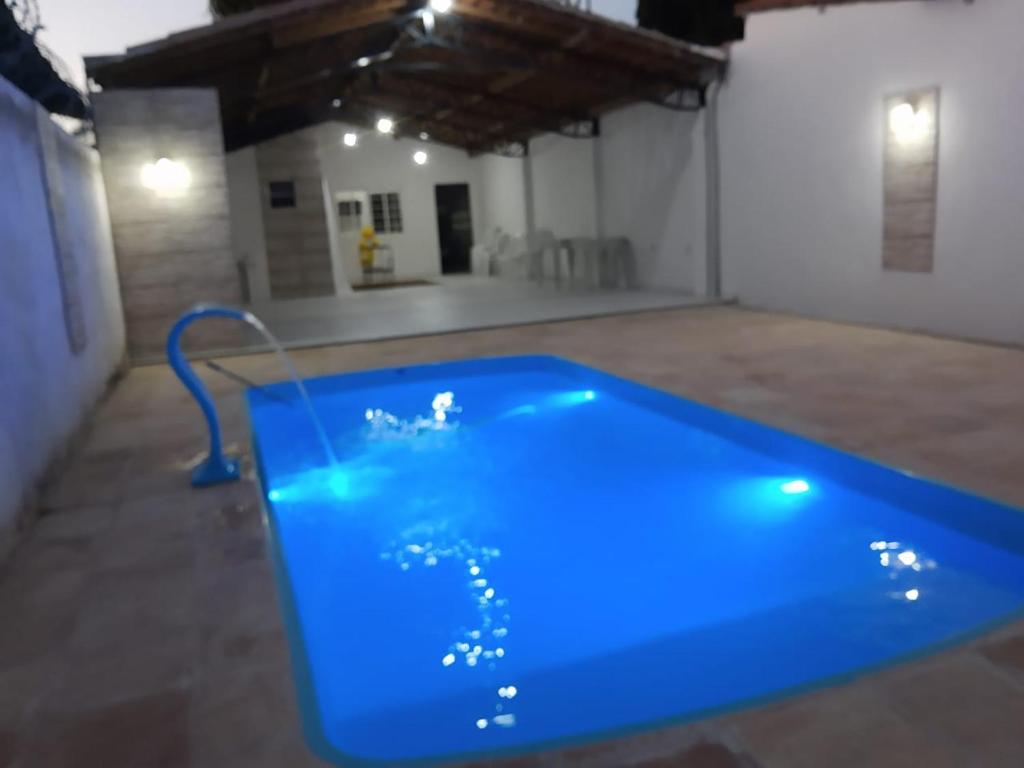 a blue swimming pool in a room with a building at Miguel Sousa Festas, Eventos e Confraternizações in Socopo